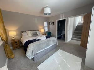 阿尔恩茅斯Alnmouth Coastal properties close to Beach with Parking的一间卧室设有一张床和一个楼梯