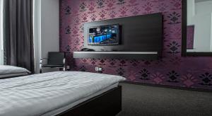普雷绍夫波罗酒店的卧室配有一张床,墙上配有电视。
