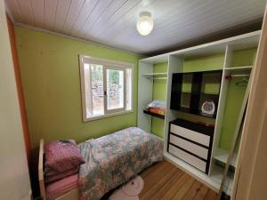 新彼得罗波利斯lugar tranquilo aconchegante perto da natureza的一间卧室设有绿色的墙壁、一张床和窗户