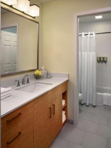 萨默塞特萨默塞特索尼斯塔ES套房酒店的一间带水槽、镜子和淋浴的浴室