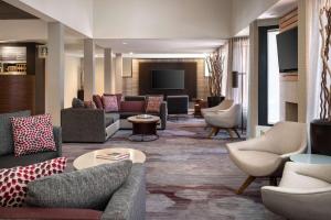 凤凰城凤凰城卡梅尔巴克万怡酒店的大堂配有沙发、椅子和电视。