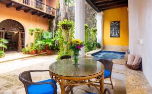卡塔赫纳Casa Baloco By Soho的一个带桌椅的庭院和一个游泳池