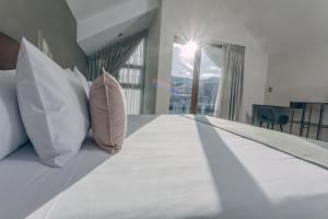 库斯科Saska Boutique Hotel的卧室配有带枕头的床铺和窗户。