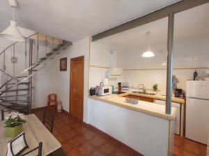 韦尔瓦Casa Villa El Olivar的厨房以及带桌子和楼梯的用餐室。
