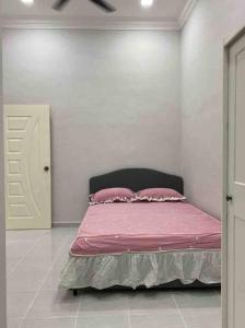 Pakaafza Homestay Paka A的一间卧室配有一张带粉色床单和枕头的床。