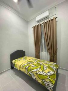 Pakaafza Homestay Paka A的一间卧室配有一张带黄色床罩和窗帘的床。