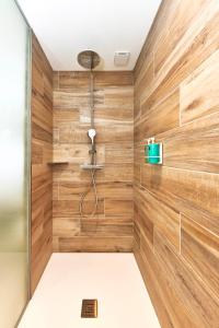 ChiroublesLa Suite的一间带木墙和淋浴间的浴室
