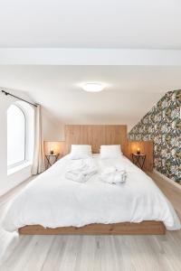 ChiroublesLa Suite的一间卧室配有一张带白色床单的大床