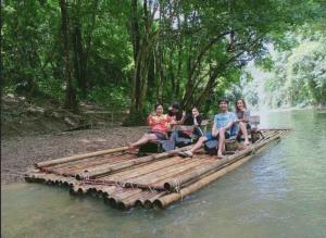 考索Billion Views Khaosok Homestay的一群人坐在水中的竹筏上