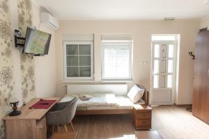 兹雷尼亚宁Zlatni Klas的客房设有床、书桌和窗户。