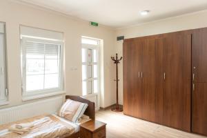 兹雷尼亚宁Zlatni Klas的一间卧室配有一张床和一个木制橱柜