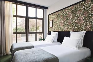 巴黎Hôtel Rosalie的配有大窗户的酒店客房内的两张床