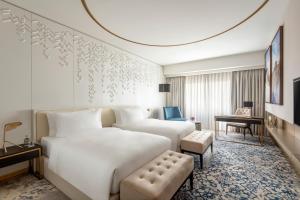 多哈Steigenberger Hotel Doha的酒店客房设有一张白色大床和椅子