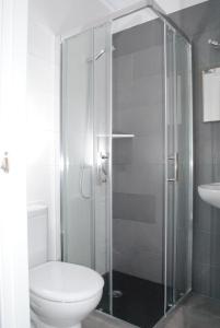 休达德亚休达德亚巴黎旅馆的一间带卫生间和玻璃淋浴间的浴室