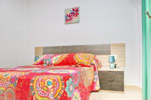 科尼尔-德拉弗龙特拉Apartamento San Ignacio Loyola的一间卧室配有一张红色棉被的床