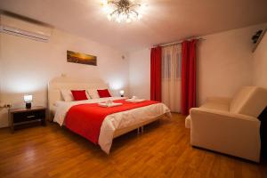 波尔Holiday Home Baki的一间卧室配有一张带红色毯子和椅子的床