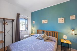 圣雷莫Domus Regina Elena的一间卧室设有一张床和蓝色的墙壁