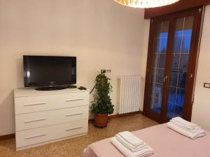 马格拉12 minuti da Venezia appartamento con parcheggio的卧室配有梳妆台,楼上配有电视