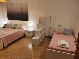 马格拉12 minuti da Venezia appartamento con parcheggio的一间卧室配有两张床和一个带灯的床头柜