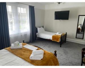 切斯特勒斯特里特The Red Lion Hotel的酒店客房,配有两张带毛巾的床