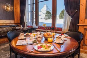 采尔马特Riffelalp Resort 2222m的一张桌子,上面放着食物,享有山景