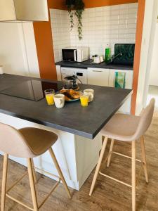 埃皮纳勒Charmant appartement的厨房配有带2把椅子的桌子和橙汁