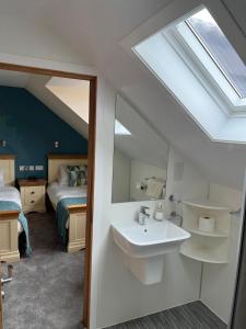 柯克沃尔卡拉瓦旅馆的一间带水槽的浴室和一间带一张床的卧室