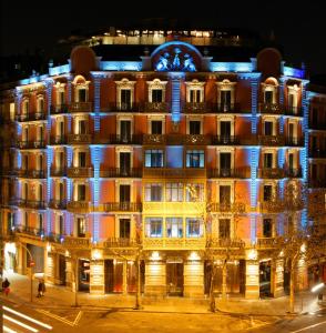 巴塞罗那Cram Hotel的一座晚上亮着蓝色灯的建筑