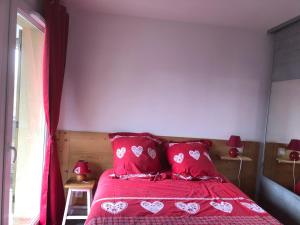 圣热尔韦莱班Charmant appartement的一间卧室配有红色的床和红色枕头