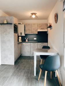 圣热尔韦莱班Charmant appartement的小厨房配有白色的桌子和两把椅子