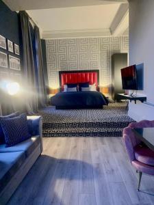 利物浦62 Castle Street Hotel的一间卧室配有一张床、一张沙发和一台电视