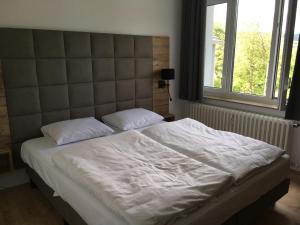 温特贝格Alte Schule Züschen-Winterberg的卧室内的一张带白色床单和枕头的床