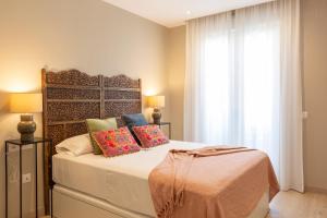 隆达Apartamentos Martalia Arenal的卧室配有带枕头的床铺和窗户。