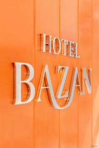 大叻RAON Bazan Hotel - STAY 24H的橙色墙上的标语,上面写着酒店巴拿