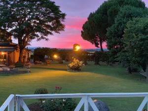 科尔托纳阿格利萨洛托酒店的白色栅栏的院子上的日落