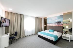 艾福雷诺德美帕幻境酒店的一间卧室配有一张床、一张书桌和一台电视。