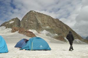 帕哈尔加姆Kashmir Outlook Adventures的一个人在雪中向两个帐篷走去