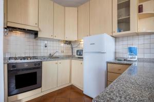 梅佐拉戈Appartamento Bellavista的厨房配有白色冰箱和炉灶。