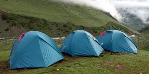 帕哈尔加姆Kashmir Outlook Adventures的两个蓝色帐篷坐在山地的田野里