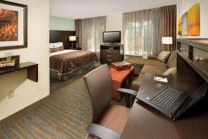 马卡姆Sonesta ES Suites Toronto Markham的酒店客房设有床和客厅。
