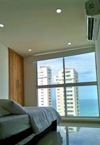 圣玛尔塔Apartamento frente al mar Rodadero Santa Marta的一间卧室设有一张床和一个大窗户