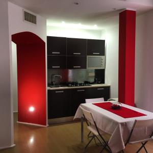 卡利亚里勒托里酒店的厨房配有桌子和红色的墙壁