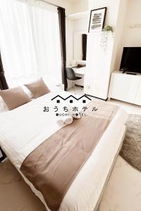 广岛OUCHI HOTEL Fujimi的一间带一张床铺的卧室,位于带书桌的房间