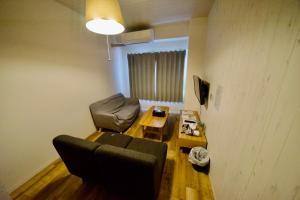 名古屋Guest House Re-worth Yabacho1 402的客厅配有沙发和桌子