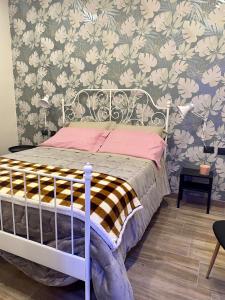 卡迈格拉特罗希拉诺B&B Staziona e Dormi的一间卧室配有一张带花卉壁纸的床