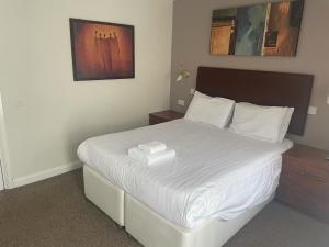 EdmondsleyThe Moorings Hotel的一间卧室配有一张带白色床单的大床