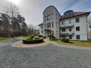 科尔萍湖Haus am Kölpinsee FW Seejuwel Objekt ID 13833-4的一座带圆形车道的大型白色房屋
