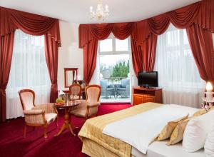 弗兰季谢克矿泉镇Imperial Spa & Kurhotel的卧室配有一张床和一张桌子及椅子