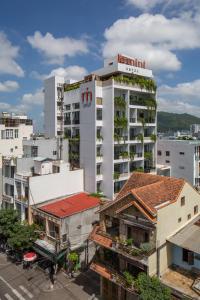 归仁Le Mint Hotel Quy Nhơn的一座高大的白色建筑,上面有植物