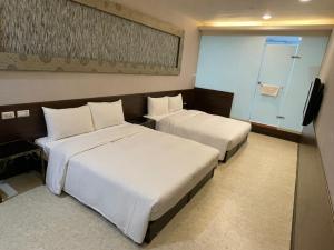 台北苓旅萬年-LIN INN Wan Nian的酒店客房设有两张床和电视。